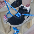 A shoe with blue shoe laces reading "#ChangeYourShoes"