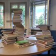 Ein Tisch mit Bücherstapeln.