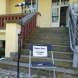 Poetry Slam in der Landeszentrale: Ein Stuhl mit der Ankündigung steht auf der Treppe vor dem Eingang