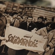 Schwarz-weiße Aufnahme einer Gruppe von Menschen, die ein Banner mit der Aufschrift 'Solidarność' halten.