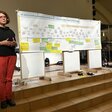 Susanne Kschenka bei Gesprächsabend in Schwante 2024. Dahinter ein Zeitstrahl mit wichtigen Ereignissen und Erinnerungen von Teilnehmern.