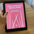 Eine Hand hält ein Tablet. Das Tablet zeigt das Bildungsmaterial "Verschwörungserzählungen. Methoden zum Umgang im Unterricht und in der außerschulischen Bildungsarbeit".
