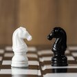 schwarz-weiße Schachfiguren stehen sich gegenüber