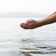 Hände schöpfen Wasser aus Naturgewässer
