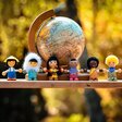 Illustration von Menschen verschiedener Nationalitäten gemeinsam vor dem Globus
