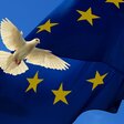 Eine Friedenstaube vor der Europafahne