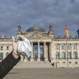 Mit einer Corona-Maske vor dem Bundestag