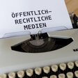Schreibmaschine mit dem Text "Öffentlich-Rechtliche Medien"