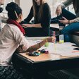 verschiedene Menschen diskutieren an einem Tisch