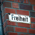 Freiheit, Straßenschild an einer Backsteinfassade. 
