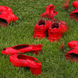 Rote Schuhe auf der Wiese als Zeichen für Gewalt gegen Frauen