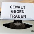 Eine Schreibmaschine mit dem Text "Gewalt gegen Frauen" auf dem Papier